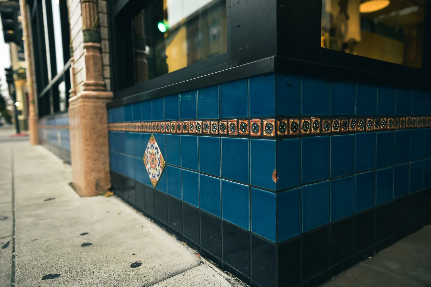 The tiled corner of a building in Napa, a band of patterned tile running along a deep blue base.